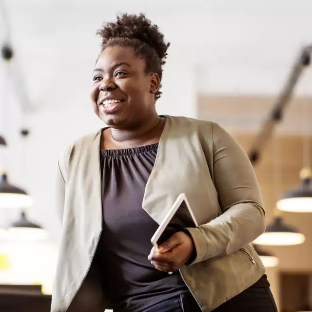 Woman smiling while holding tablet