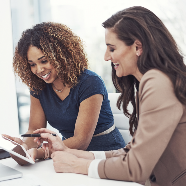 Two women working together on a tablet