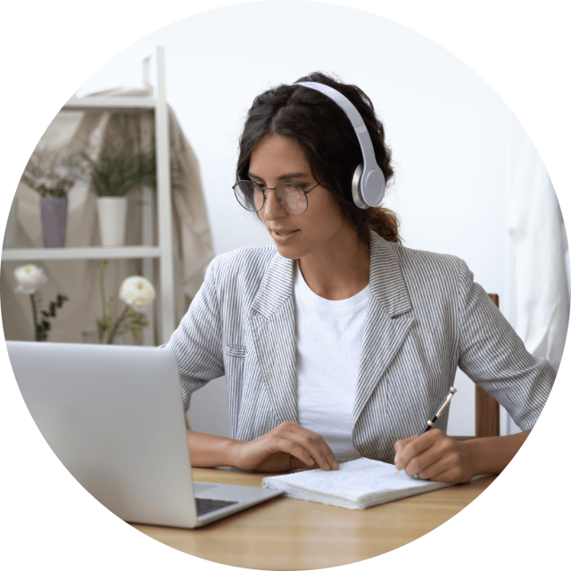 Woman wearing headphones staring at laptop