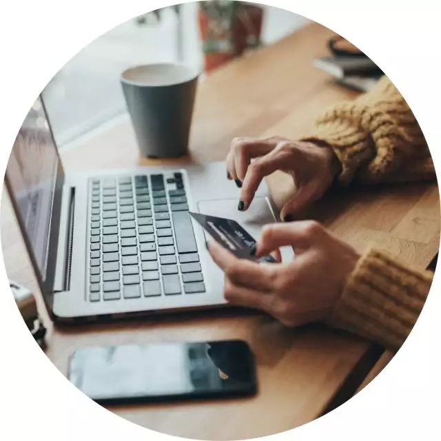 Woman using phone and typing on laptop 