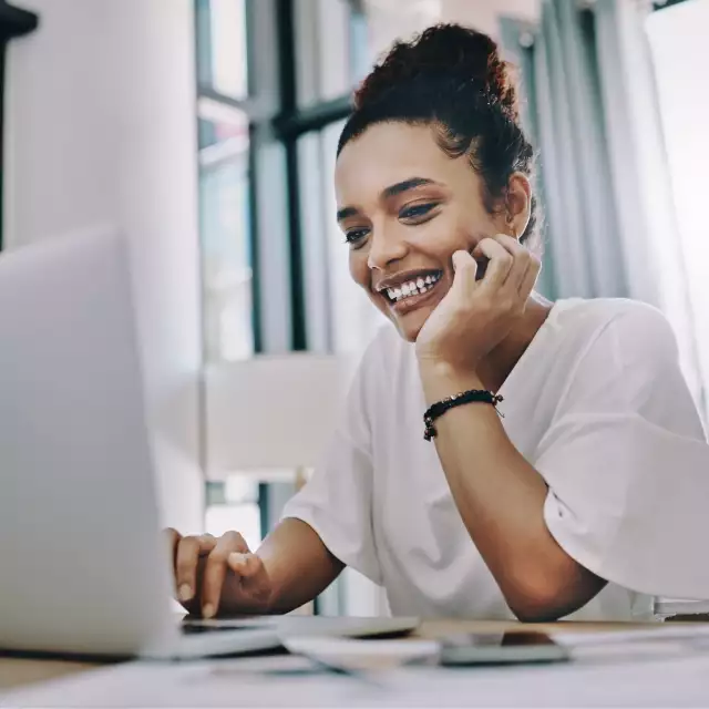 Woman smiling looking at laptop