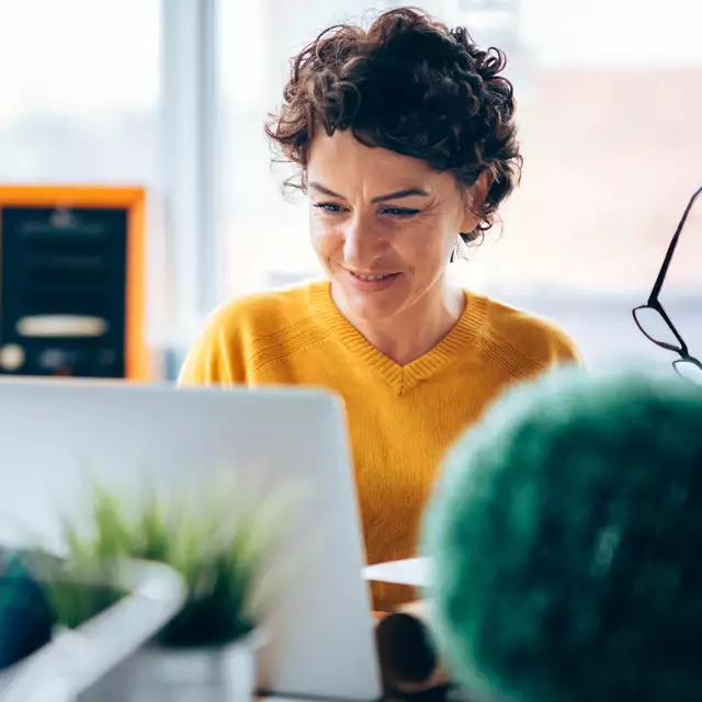 Woman smiling and working on laptop