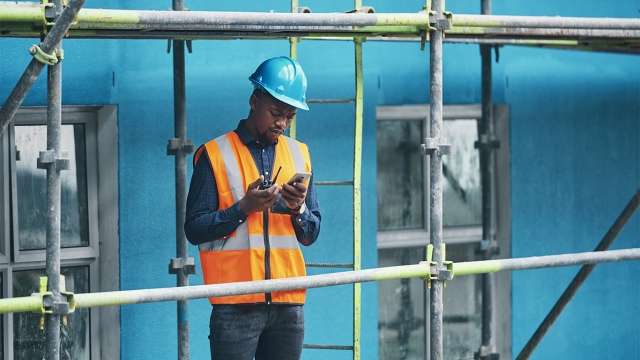 Construction worker using walkie talkie