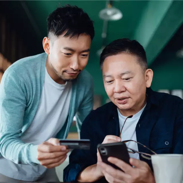 Two men inputting credit card information on phone