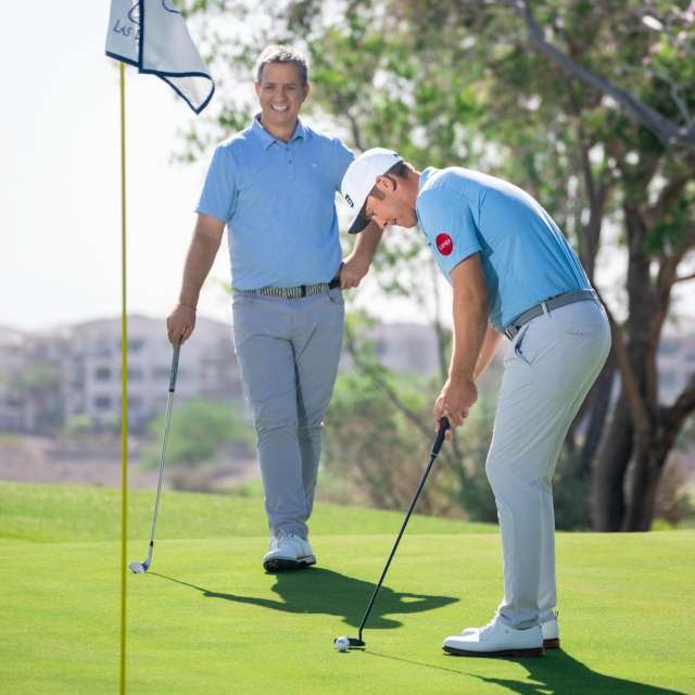 Seamus Powers and Noel Goggin standing on a golf course smiling