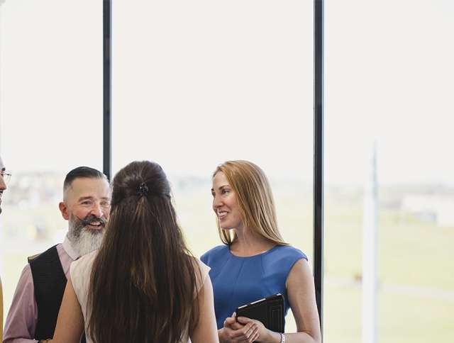 Four coworkers standing and talking