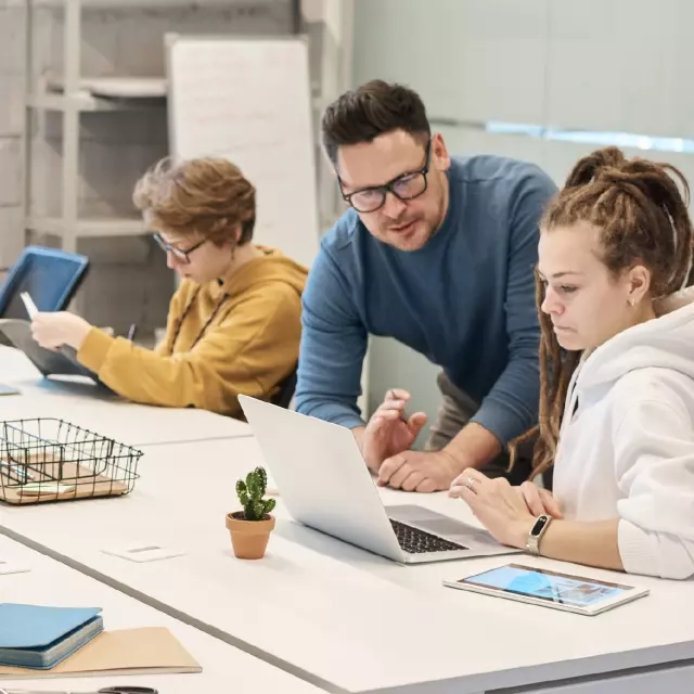 Professor assisting a student on her laptop