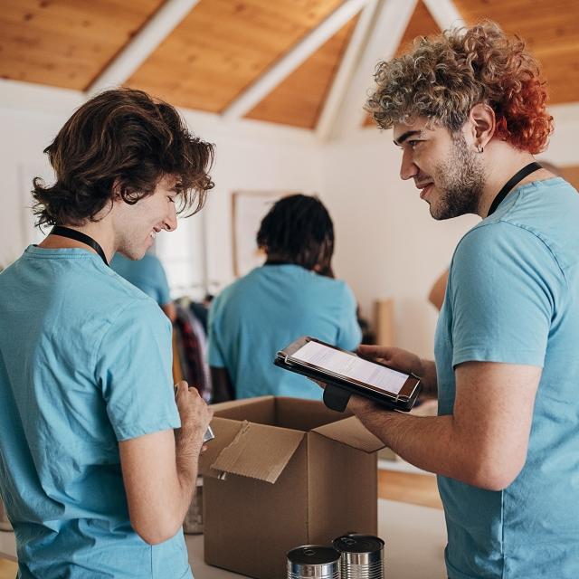 Person signing volunteers in with a tablet