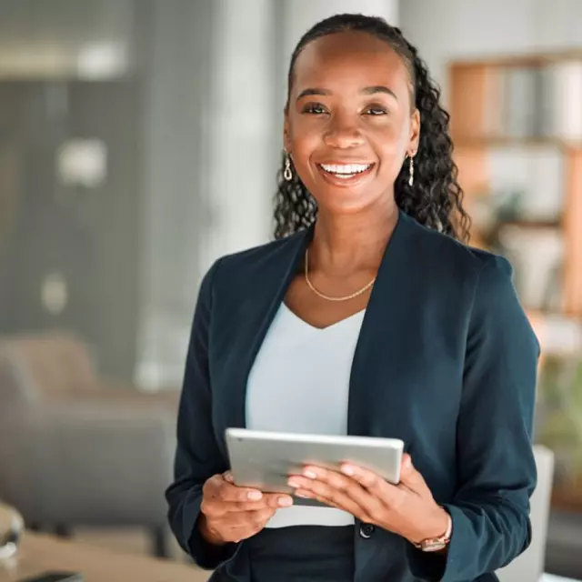 Business professional in a modern office holding a tablet, representing digital contract lifecycle management and streamlined business operations.