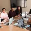 8 people sit around a conference table in discussion